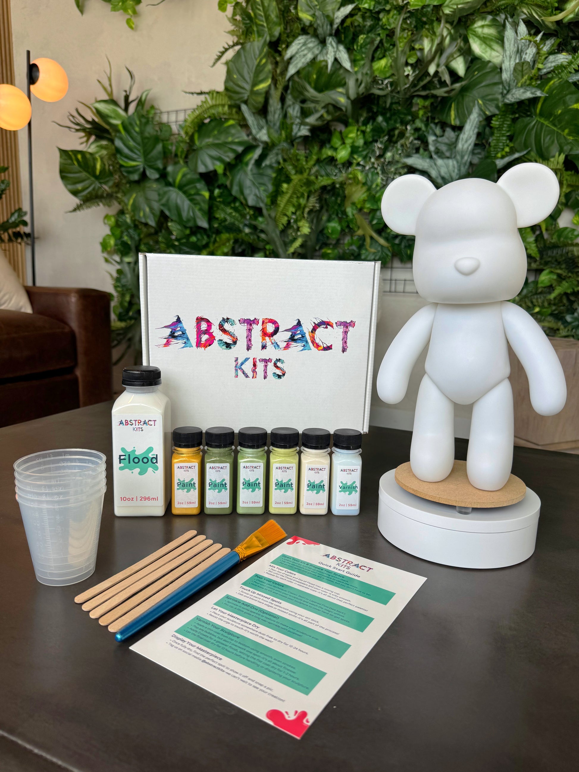 Yearling fluid art kit by Abstract Kits, featuring a blank 13-inch acrylic bear sculpture alongside paint, flood, varnish, mixing cups, guide, and all included DIY art supplies.