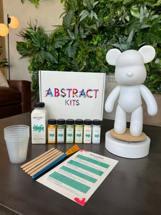 Yearling fluid art kit by Abstract Kits, featuring a blank 13-inch acrylic bear sculpture alongside paint, flood, varnish, mixing cups, guide, and all included DIY art supplies.