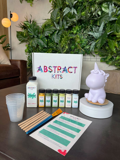 Fluffy fluid art kit by Abstract Kits, featuring a blank 7-inch acrylic unicorn sculpture alongside paint, flood, varnish, mixing cups, guide, and all included DIY art supplies.