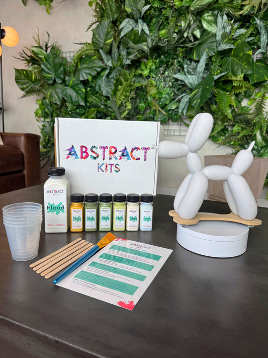 Snoopy fluid art kit by Abstract Kits, featuring a blank 10-inch resin balloon dog sculpture alongside paint, flood, varnish, mixing cups, guide, and all included DIY art supplies.